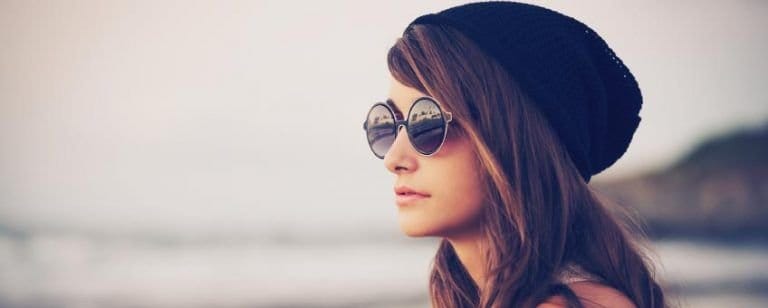 10 cosas que debes saber si quieres dejar de FUMAR 2 Mujer joven de perfil con gorro de lana y gafas de sol frente al mar