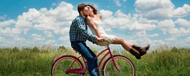 ¡S.O.S!: La convivencia está arruinando nuestra relación de pareja 8 Pareja besandose sobre una bicicleta en el campo, ella sentada en el manillar, con complicidad