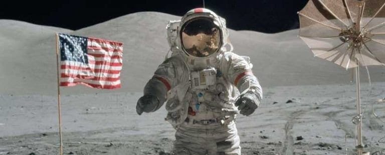 ¿Cómo es una primera consulta con un Psicólogo/a? 3 Astronauta de pie sobre el polvo lunar junto a la bandera, en un terreno desconocido