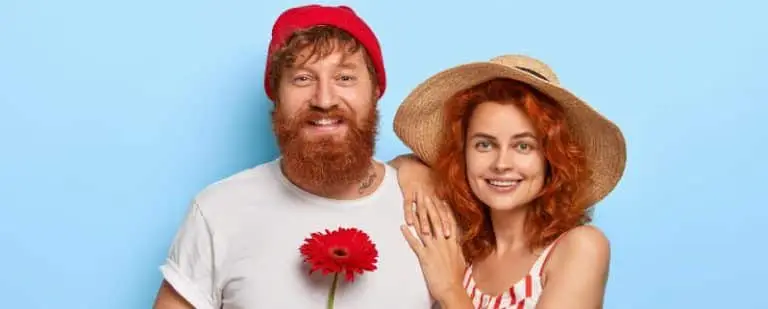 ¿Es tóxica mi relación de pareja? 4 Pareja pelirroja sonriente posando junta, él con gorro rojo y flor, ella con sombrero de paja