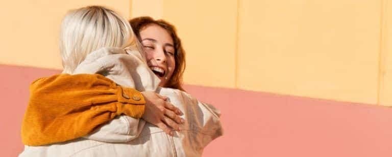 10 pautas para ayudar a un familiar a superar su adicción a la cocaína 3 Dos mujeres jóvenes se abrazan con fuerza al sol, en un gesto de apoyo cercano
