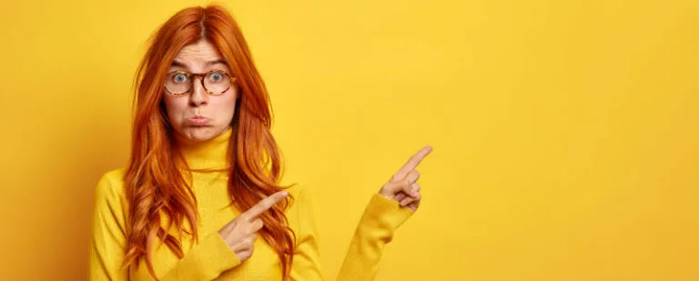 Me ha hecho daño: ¿la intención importa? 3 Mujer pelirroja con gafas señala hacia un lado con los ojos muy abiertos y gesto de desconcierto